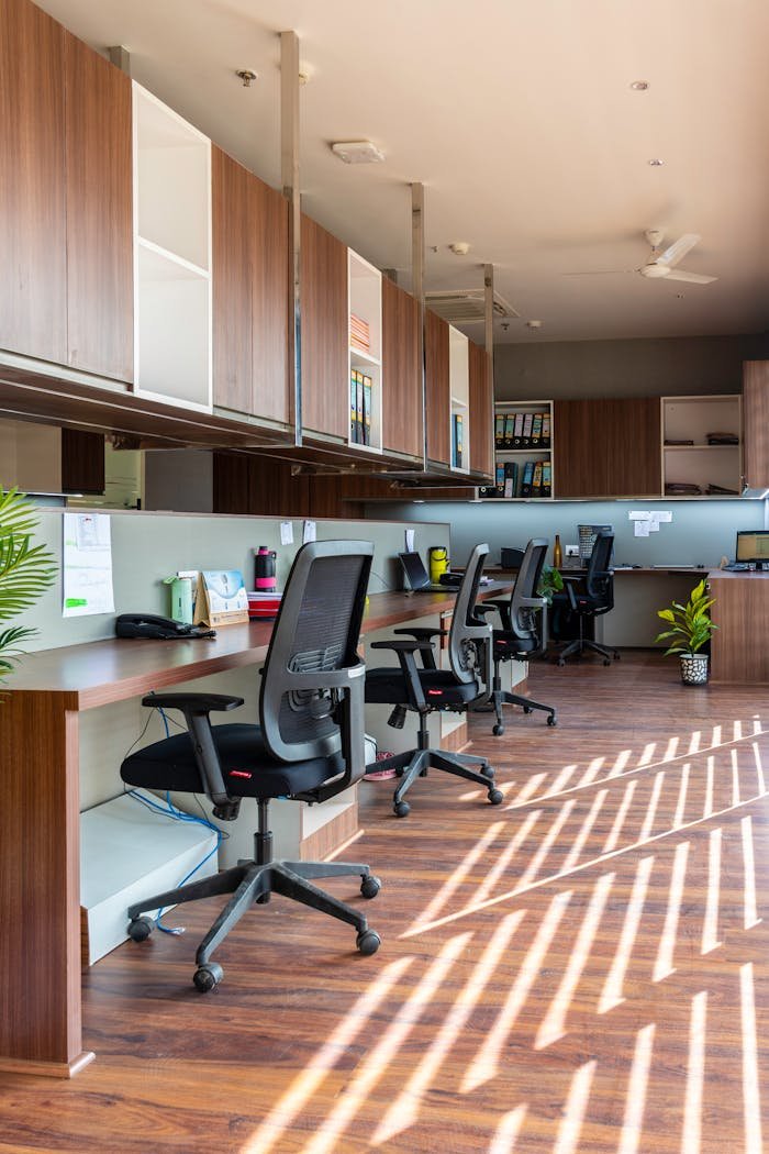 our-experience Bright and spacious open office with wooden desks and chairs under natural light. Ideal for creative workspaces.