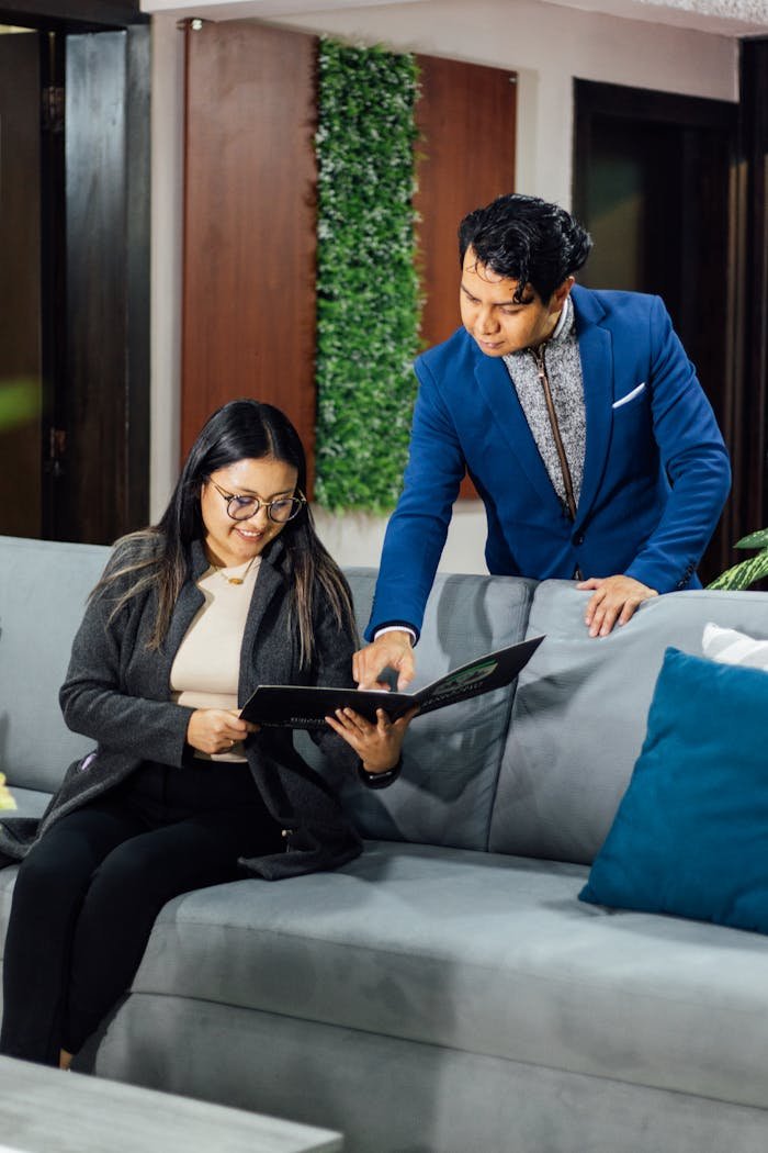 Two professionals reviewing documents in a stylish office lounge setting.