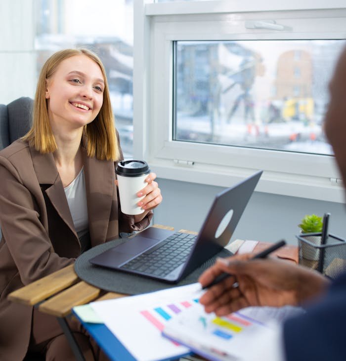 Smiling businesswoman enjoying a coffee break in a modern office.